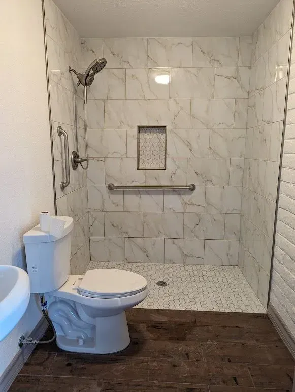 A bathroom with green tiles and a shower curtain.