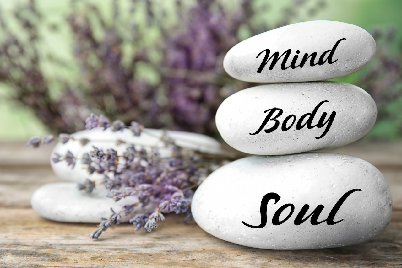 Image of three balanced rocks with lavender and the words: Mind, Body Soul