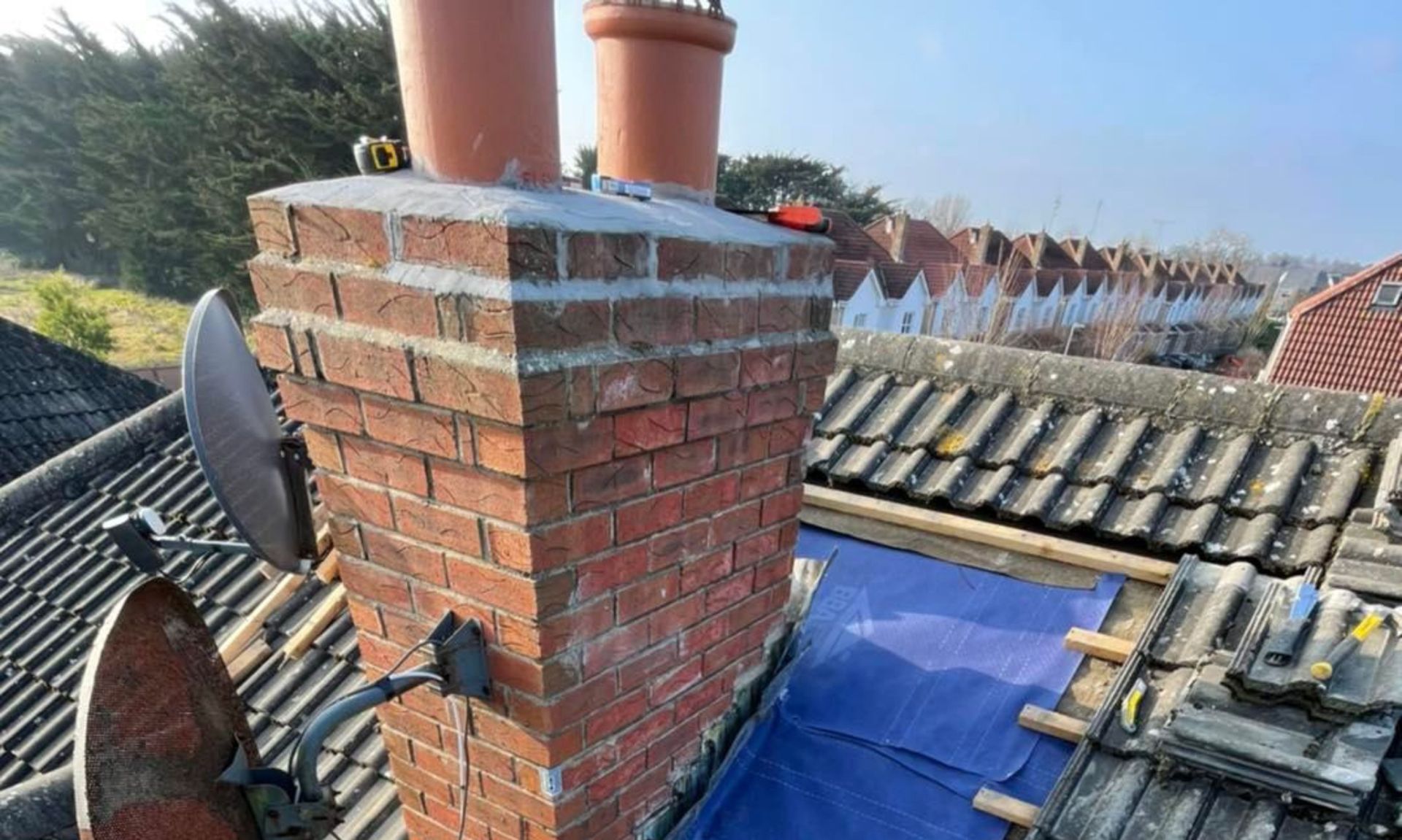 A brick chimney is sitting on top of a roof.