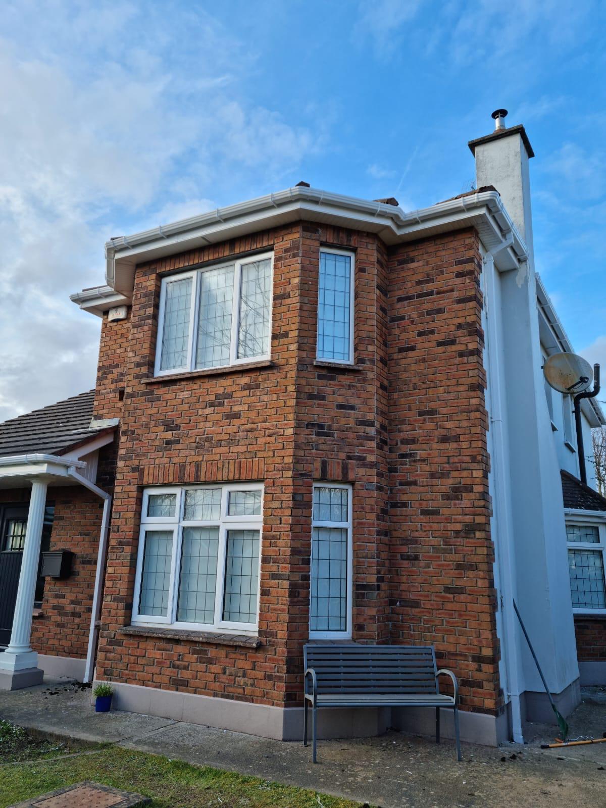 A brick house with a bench in front of it.
