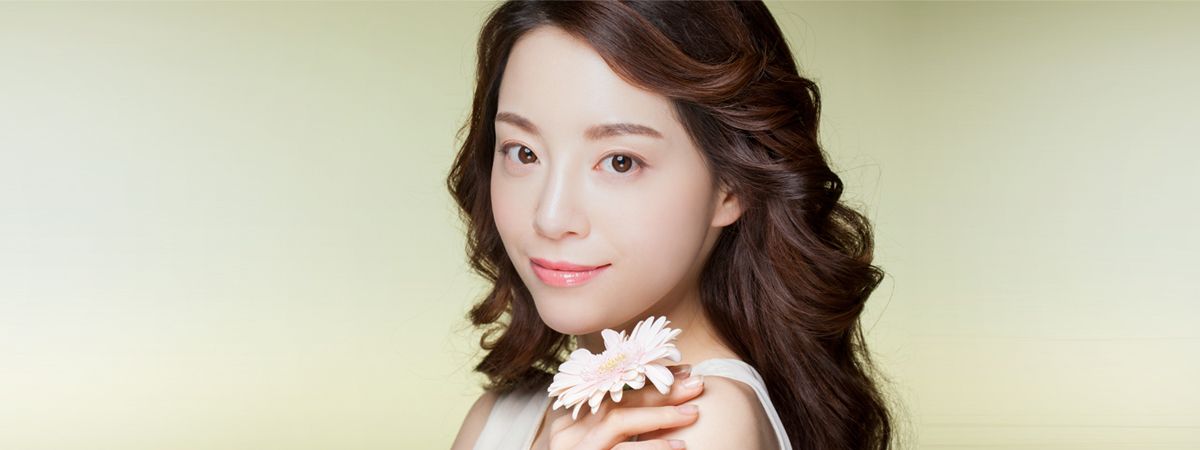 Woman holding a flower representing vaginal atrophy and menopause care in Seoul