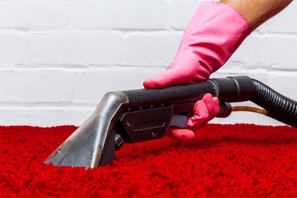 A Mop Is Sitting On A Wooden Floor Next To A Couch — Lake Macquarie Carpet Cleaning In Warners Bay, NSW