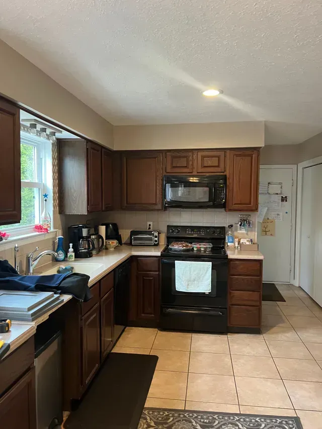 A Kitchen with Wooden Cabinets and A Black Stove