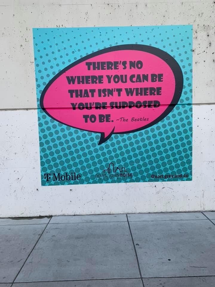 A street mural shows a pink speech bubble with 