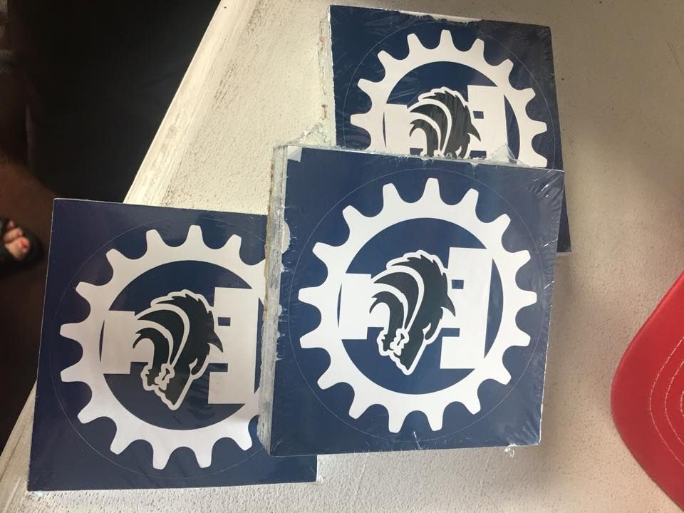 Three square blue stickers featuring a white gear symbol enclosing a white horse head logo on a white surface.