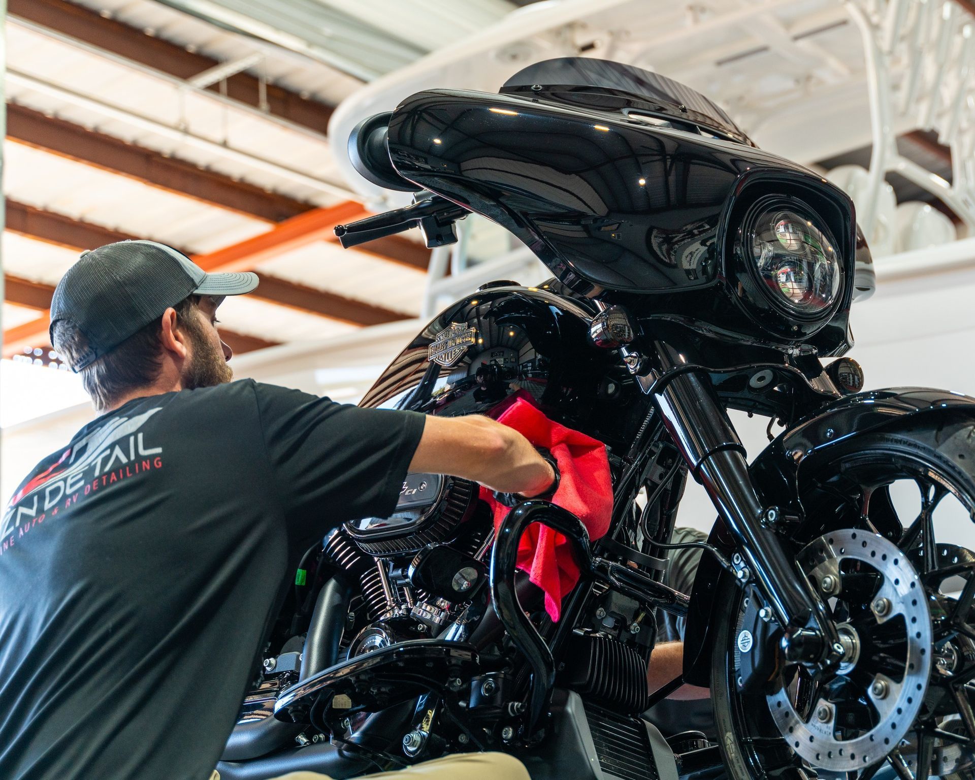 A man is detailing a Harley Davidson motorcycle.