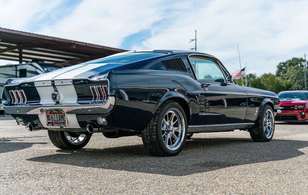 A black and white mustang is parked in a parking lot.