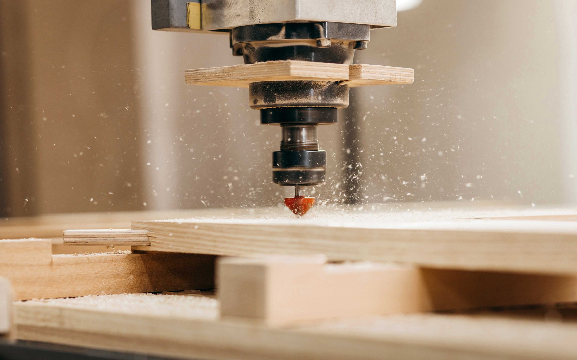 Machine CNC coupant du bois et produisant de la sciure.
