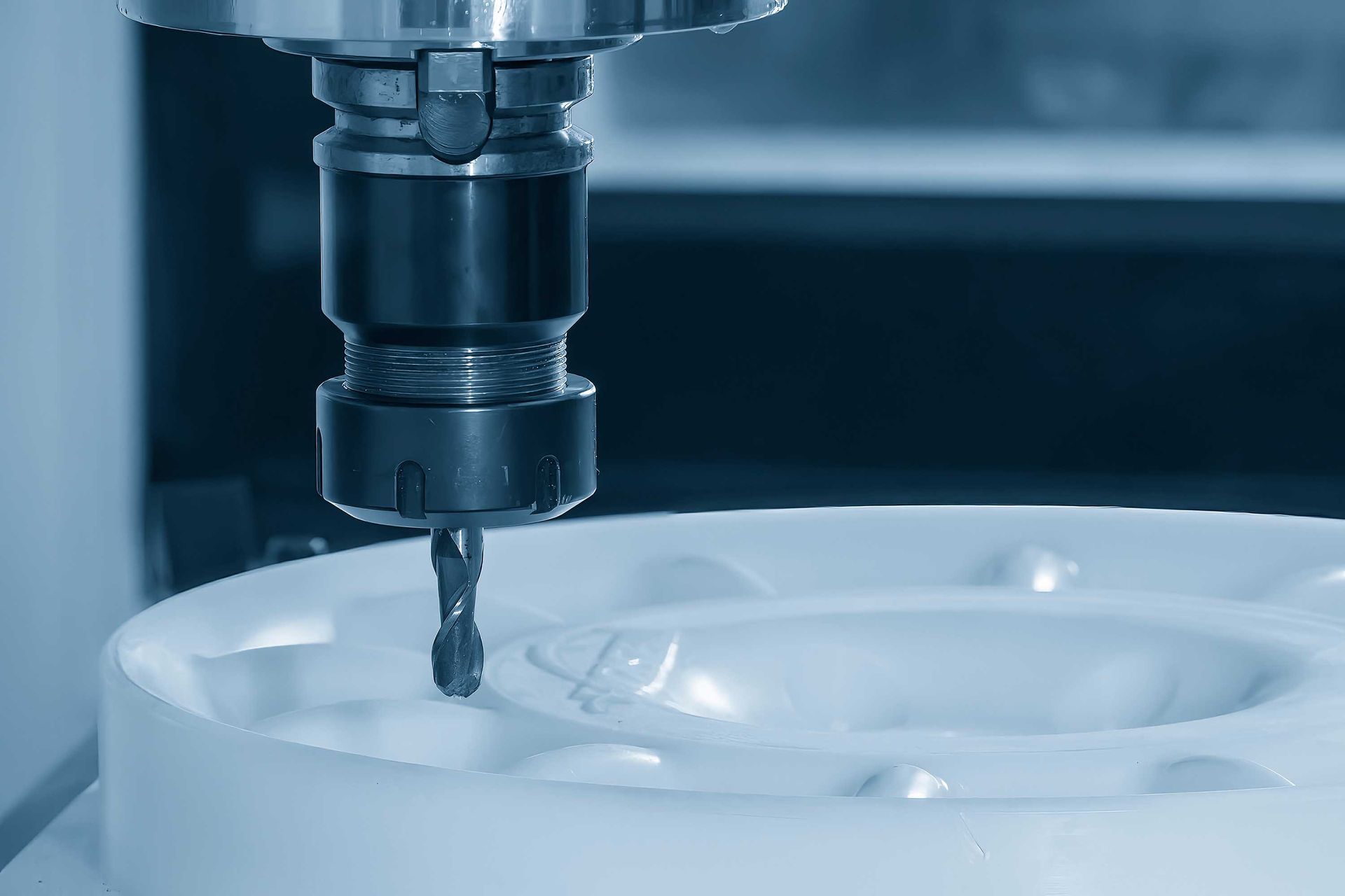 Machine CNC fraisant une pièce circulaire blanche.