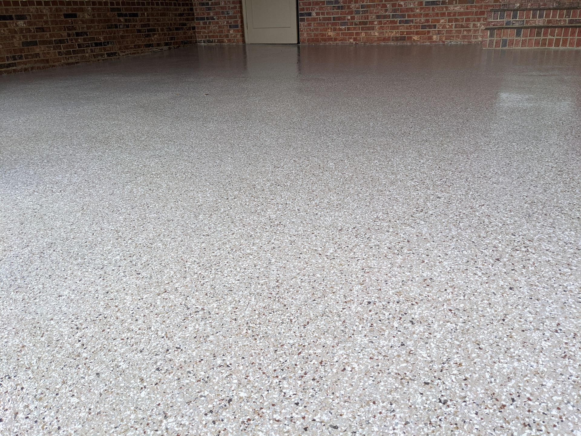 A garage floor with a brick wall in the background.