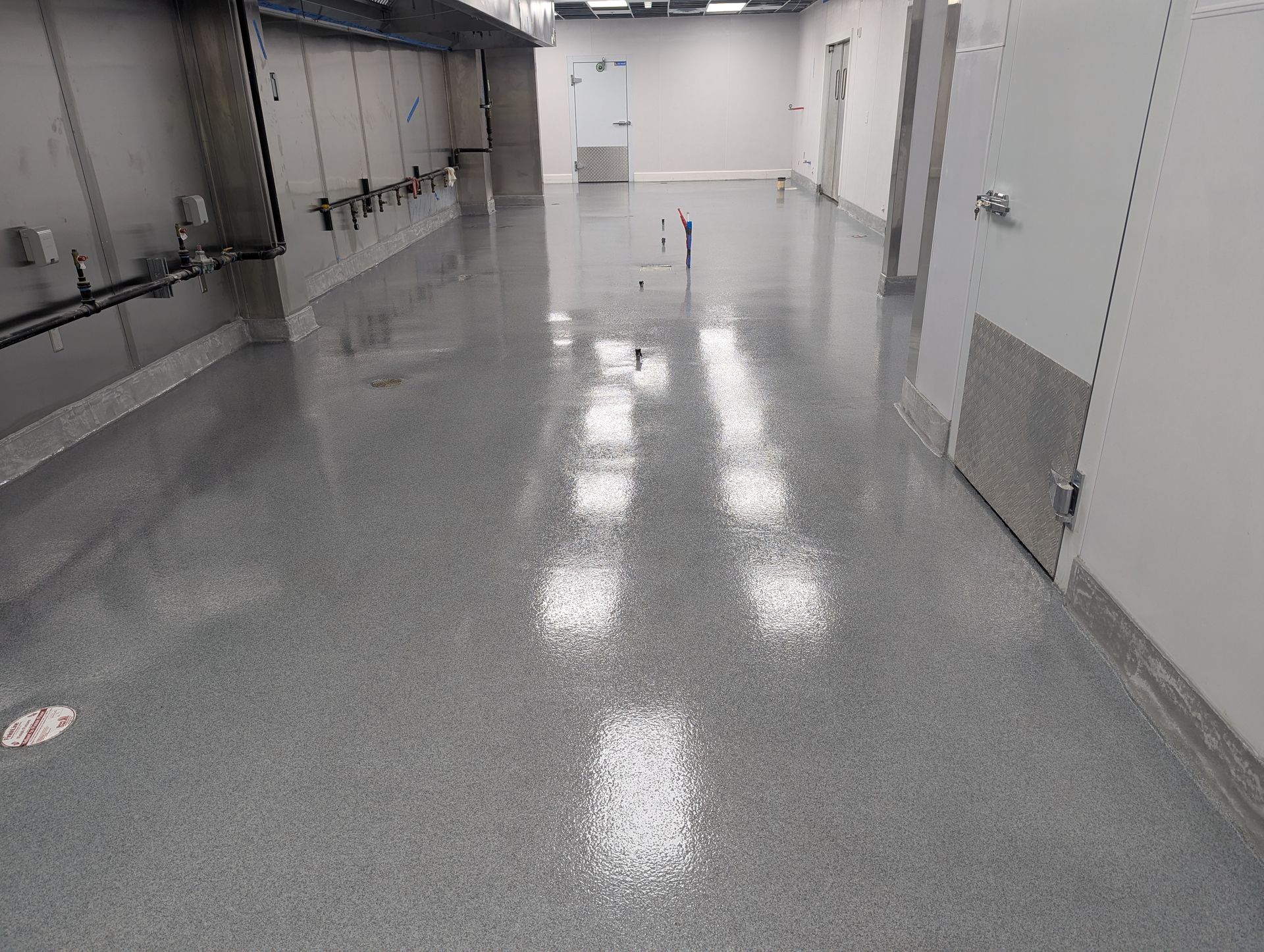 A large room with a shiny floor and a lot of doors.