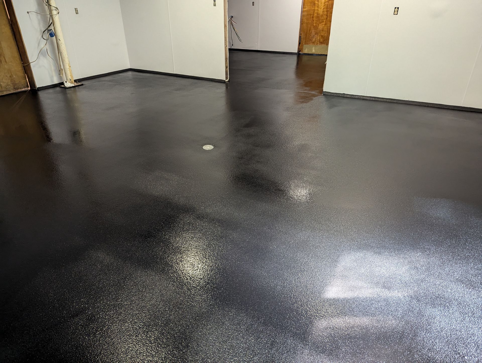 A room with a black floor and white walls.