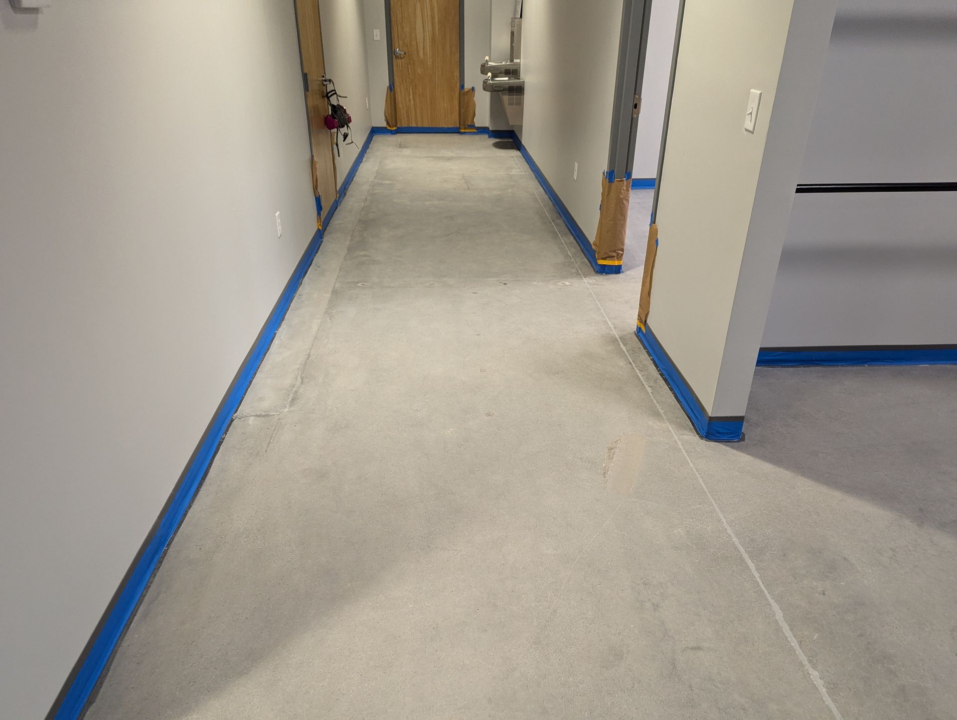 A long hallway with blue tape on the walls and floor.