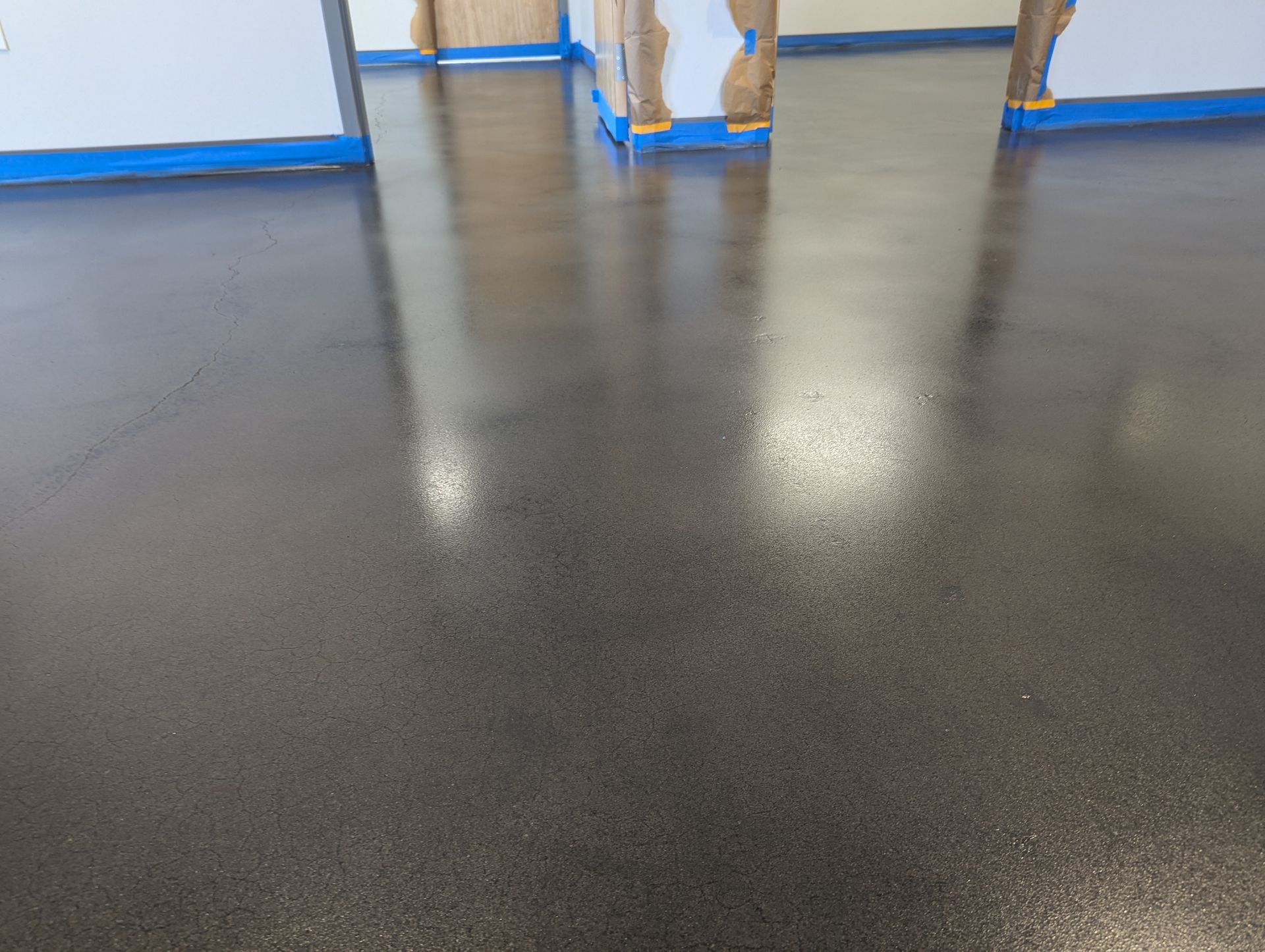 A close up of a shiny black floor in a room.
