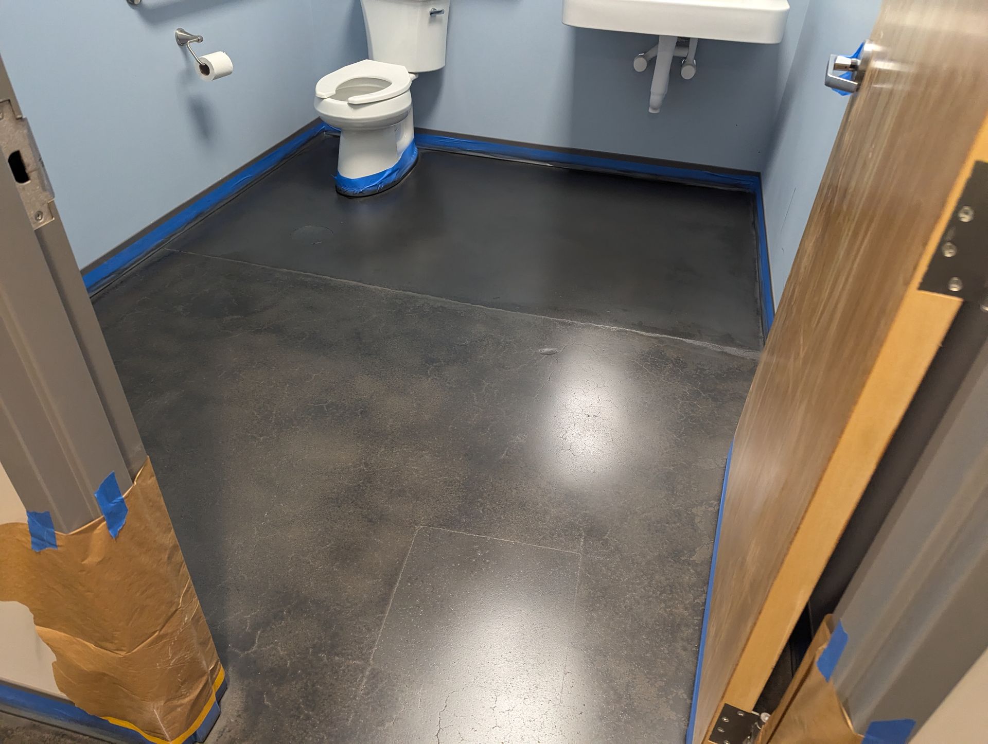 A bathroom with a toilet , sink , and blue walls.
