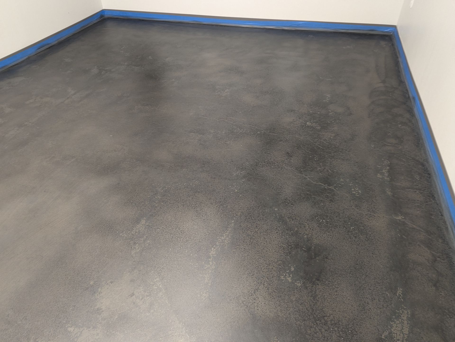 A room with a black floor and a white wall.