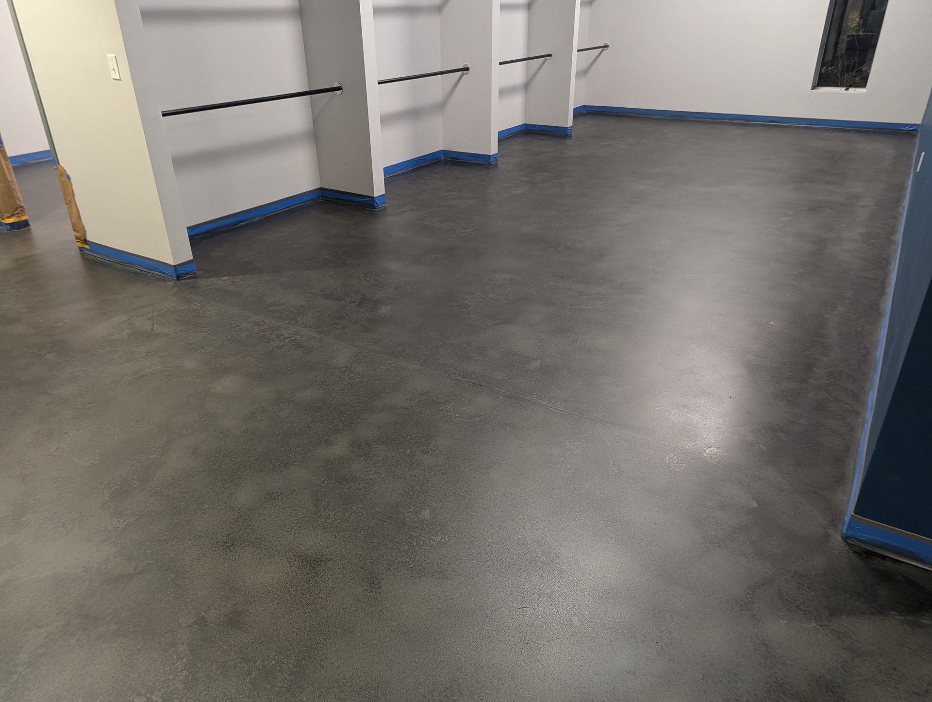 A room with a concrete floor and a row of shelves.