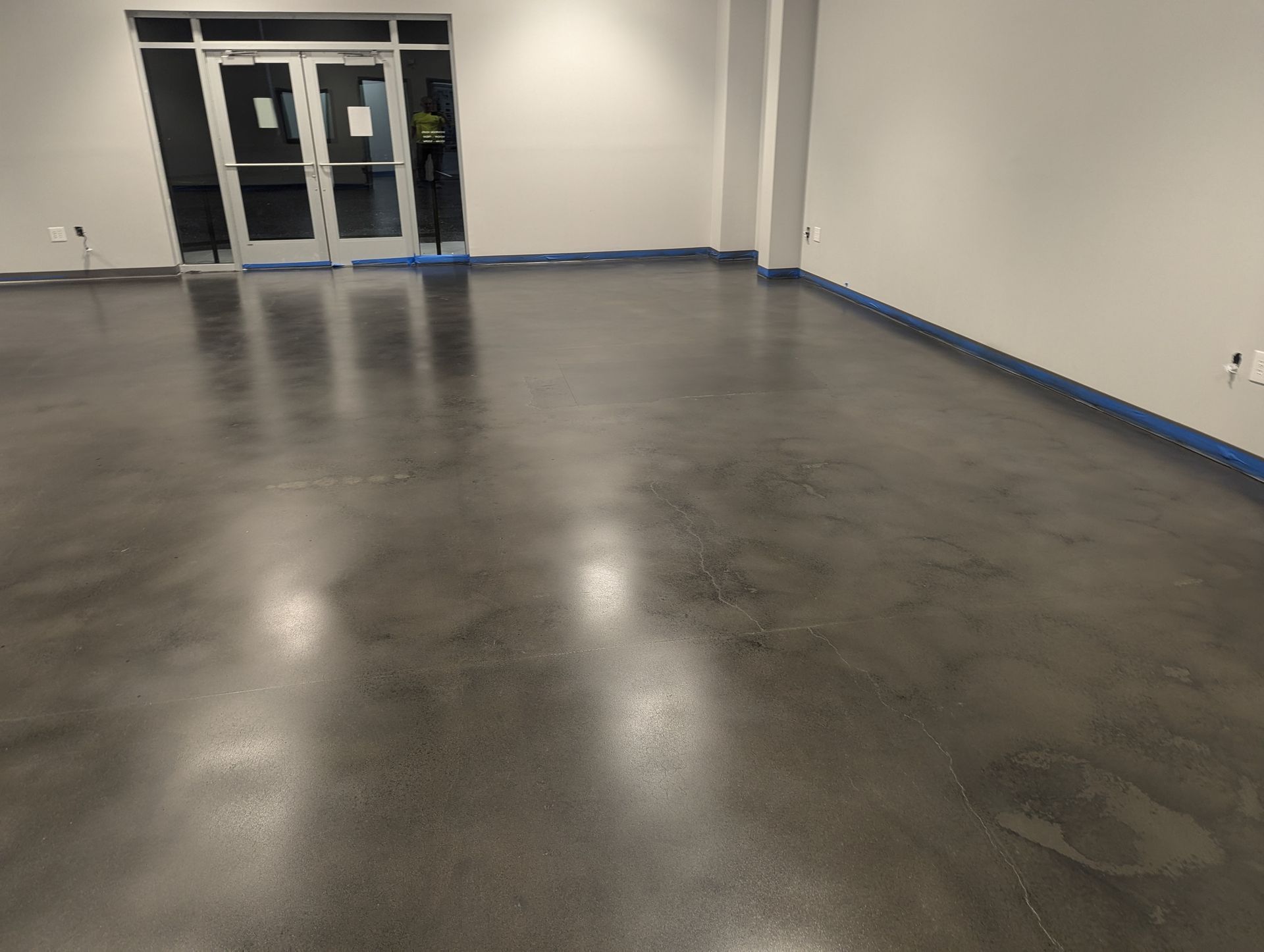 A large room with a concrete floor and a door.