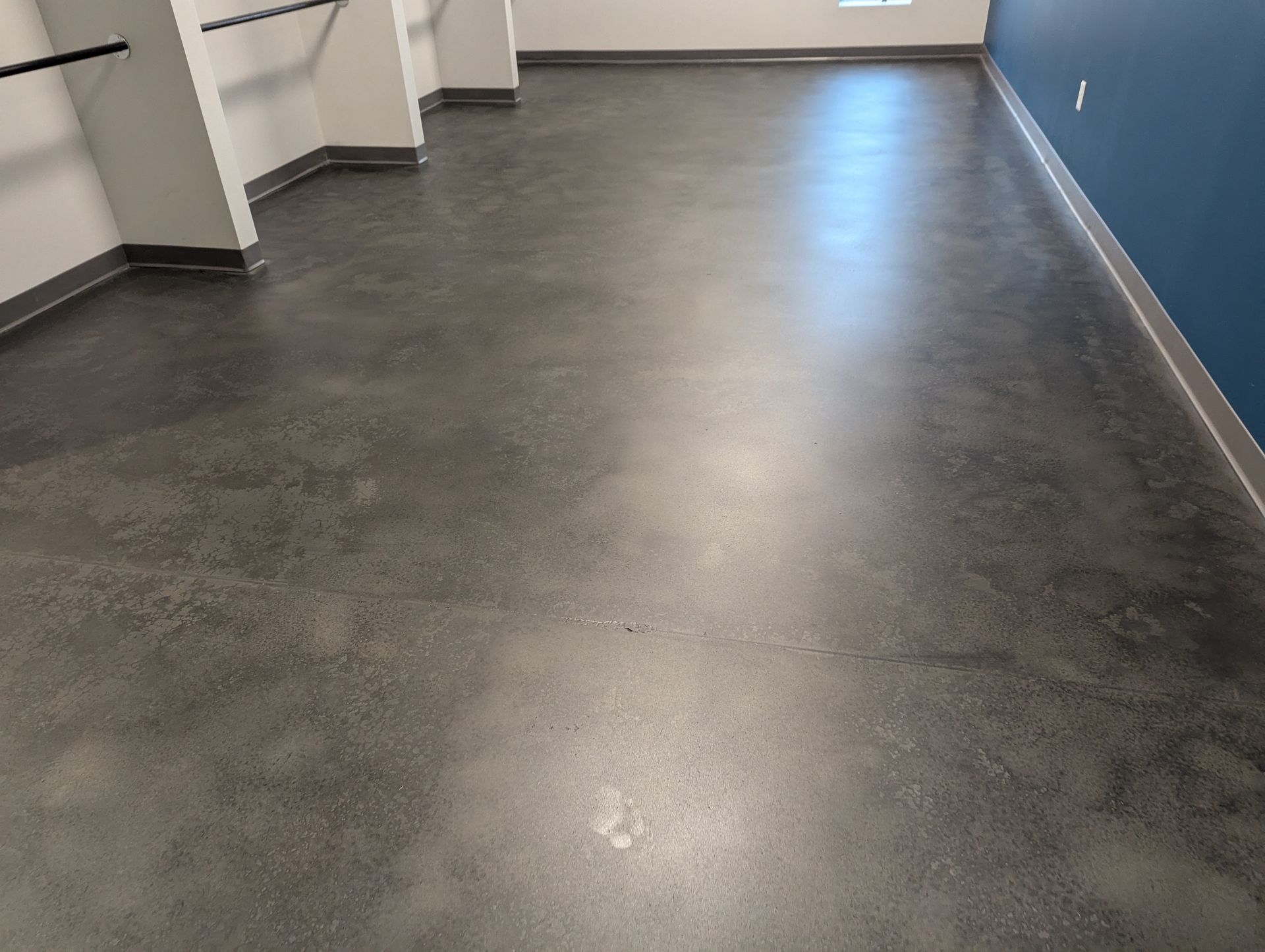 A room with a gray floor and a blue wall.