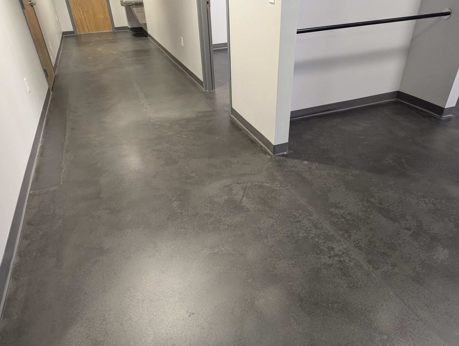 A hallway with a gray floor and white walls
