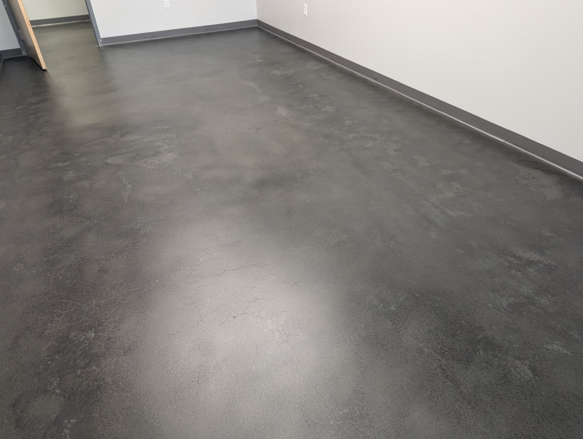 A room with a black floor and white walls.