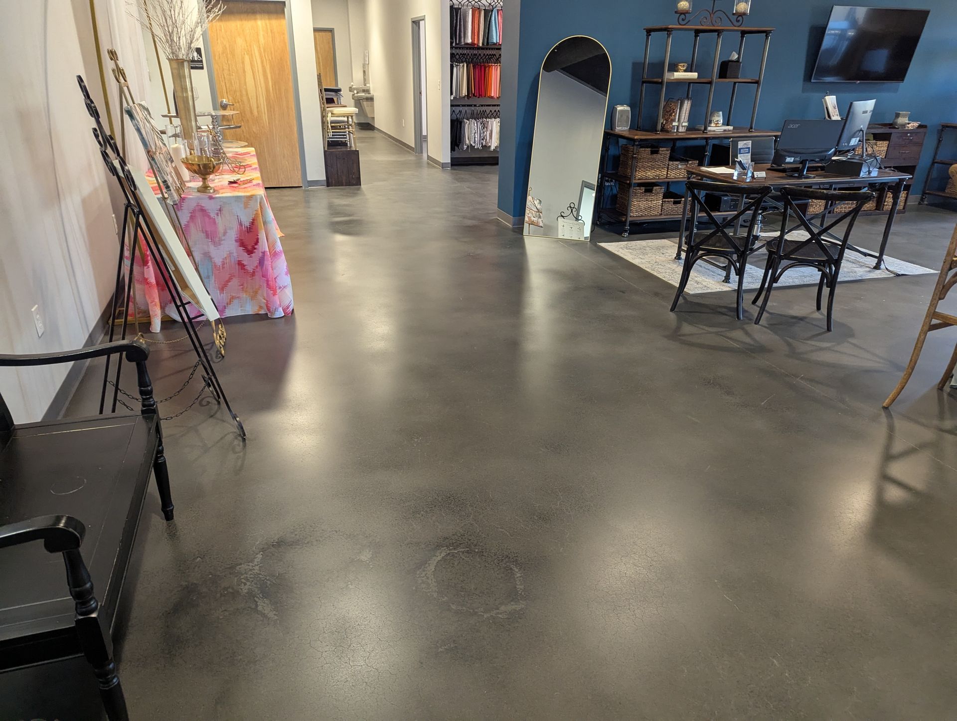 A large room with a concrete floor and a table and chairs.