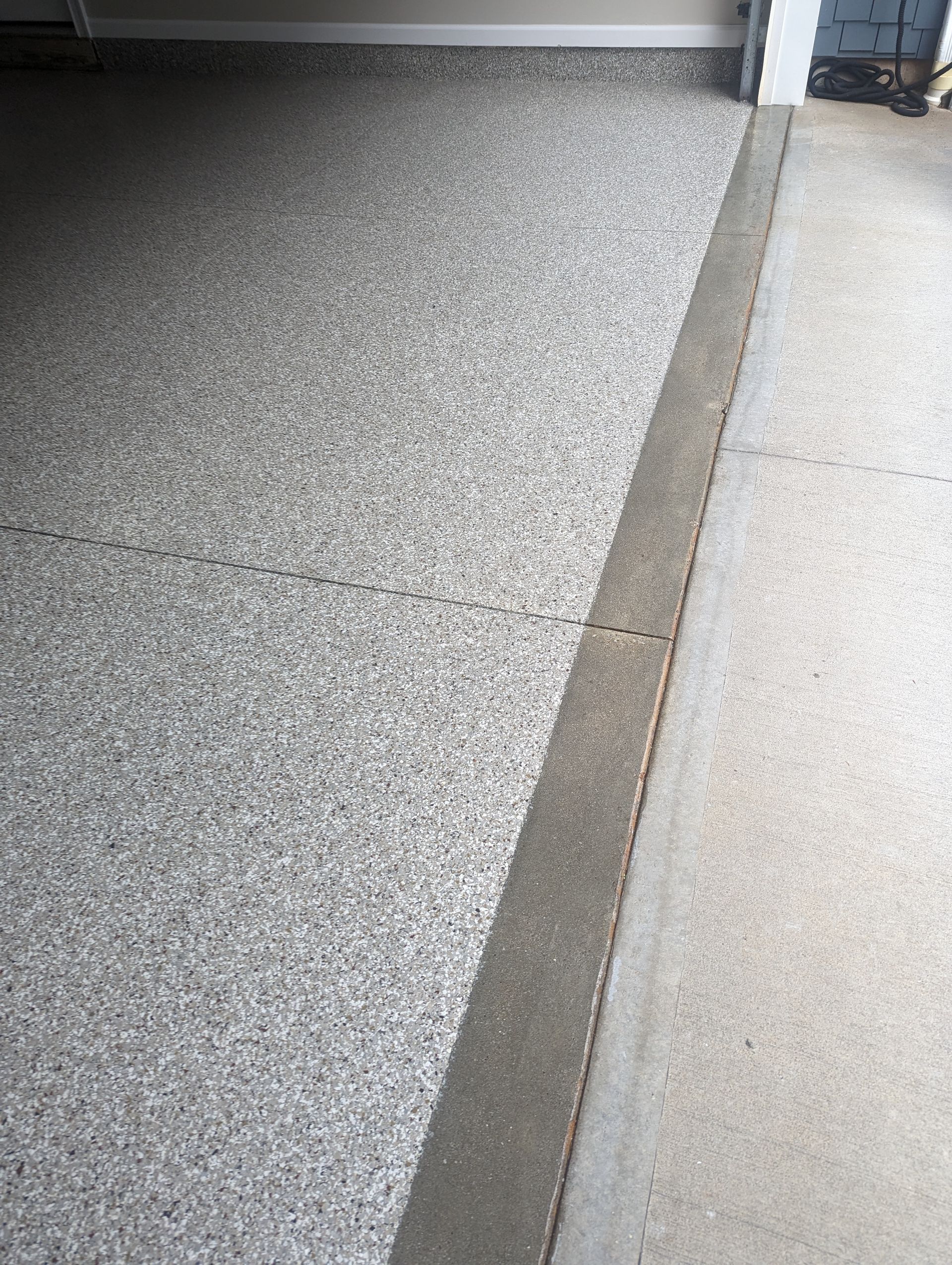 A close up of a garage floor with a concrete curb.
