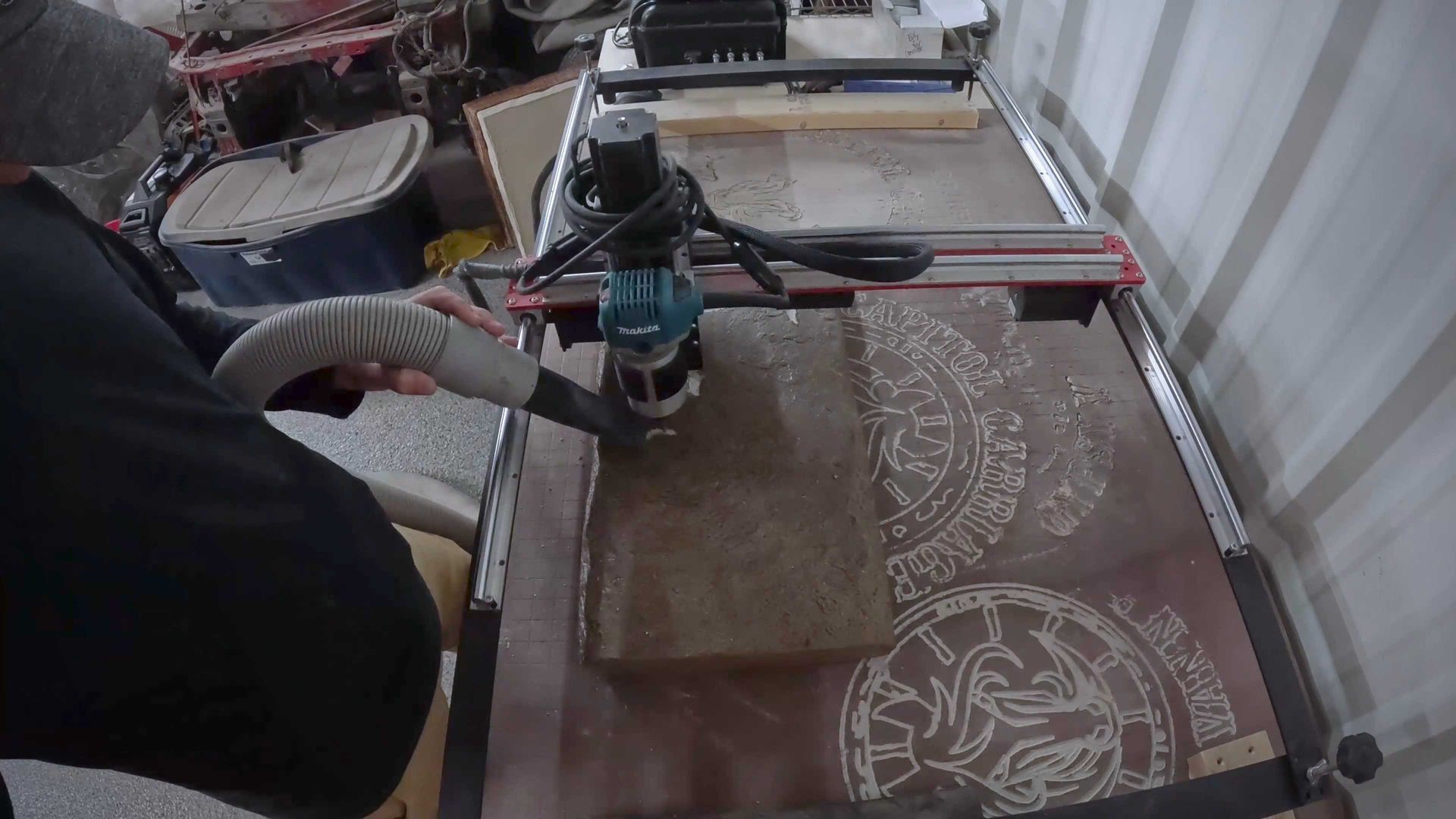 A person is using a machine to engrave a piece of stone.