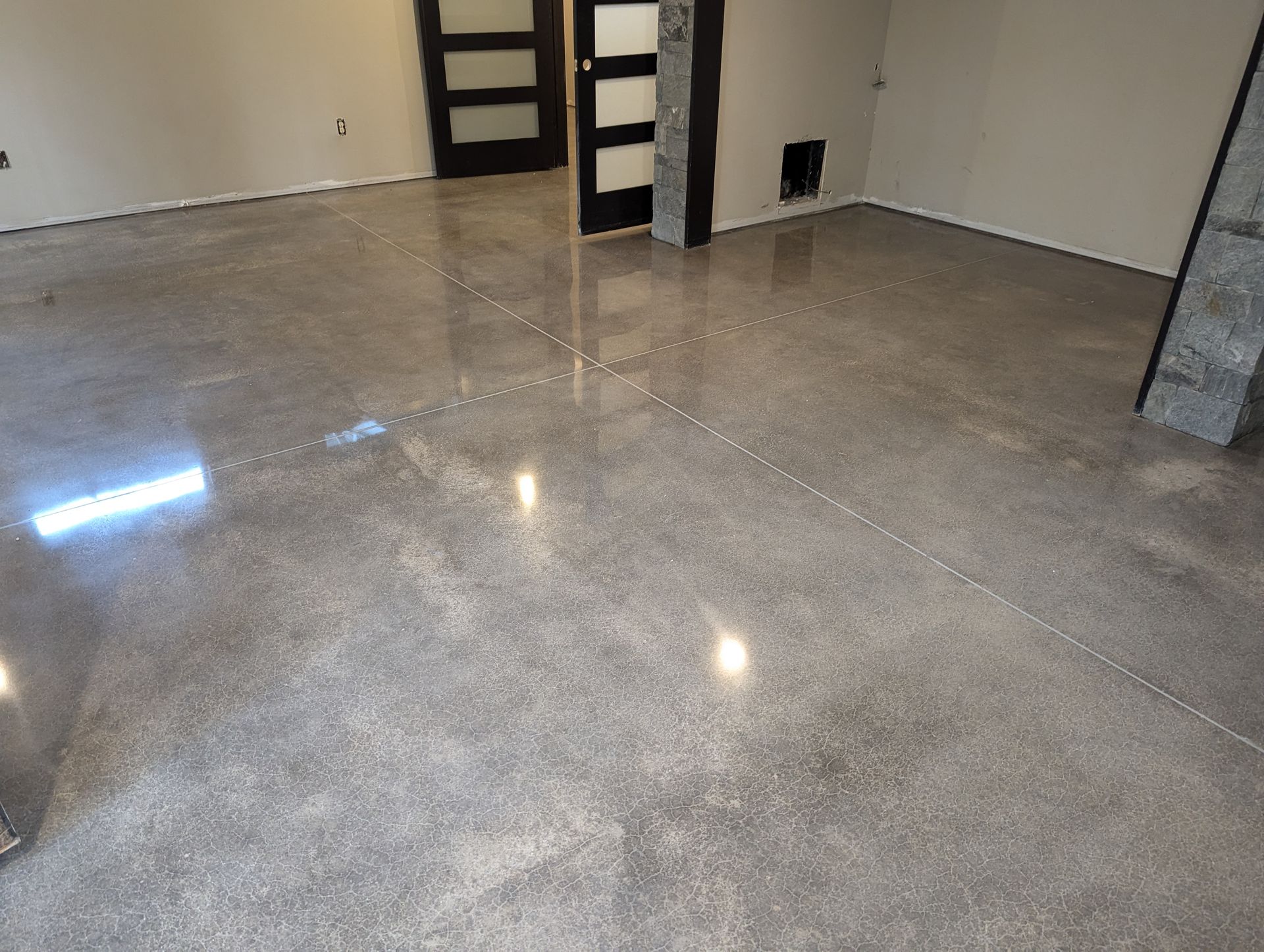 A shiny concrete floor in a room with a door.