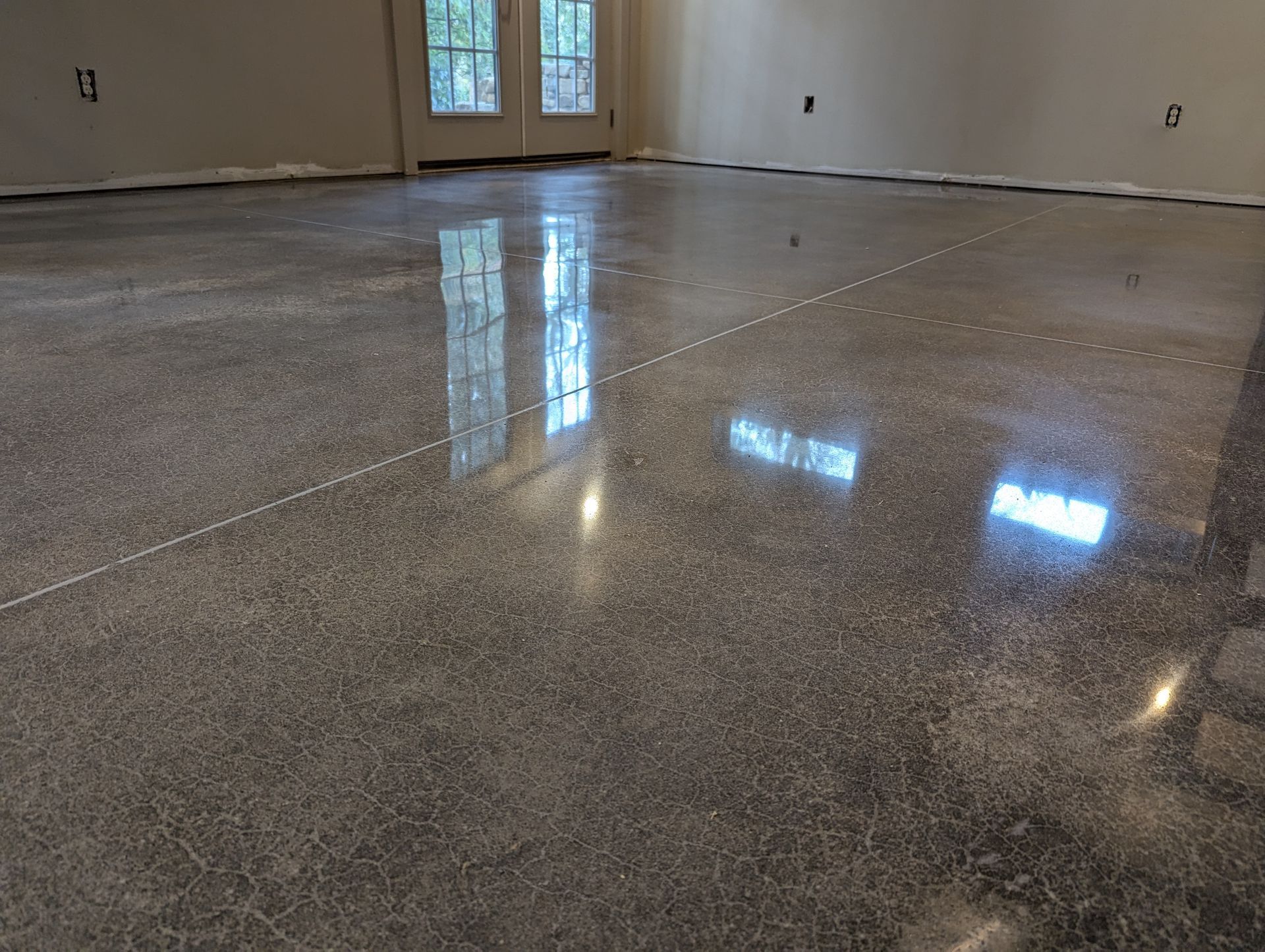 A man is using a vacuum cleaner to clean a concrete floor.