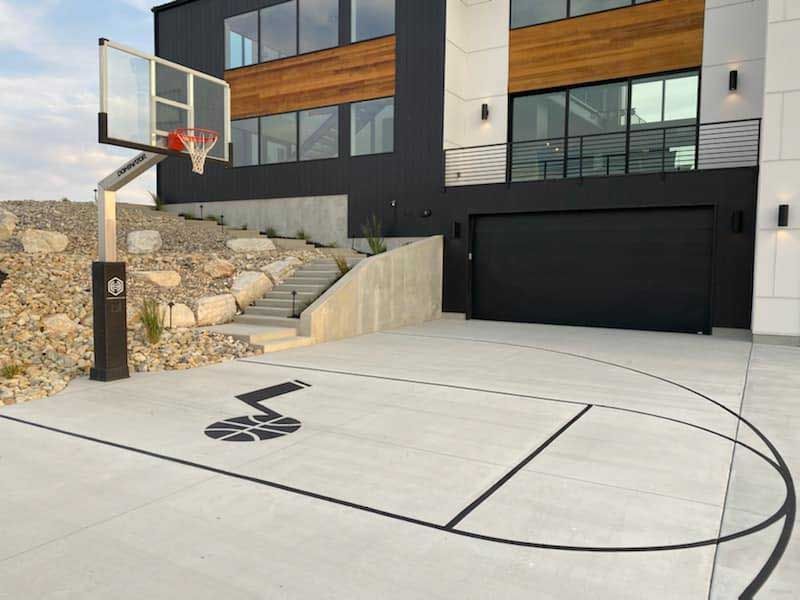 There is a basketball hoop in the driveway of a house.