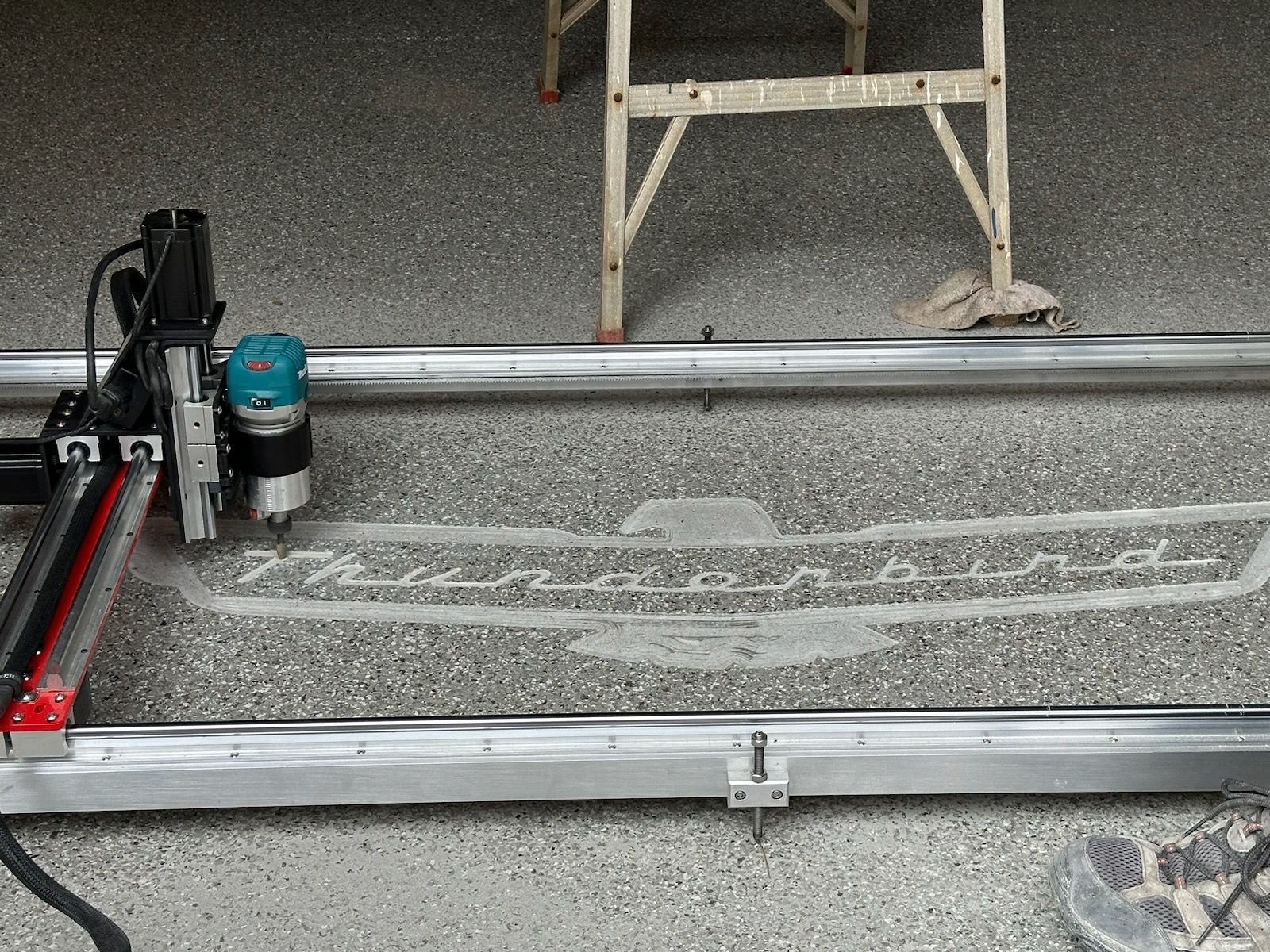 A machine is sitting on a concrete floor next to a ladder.