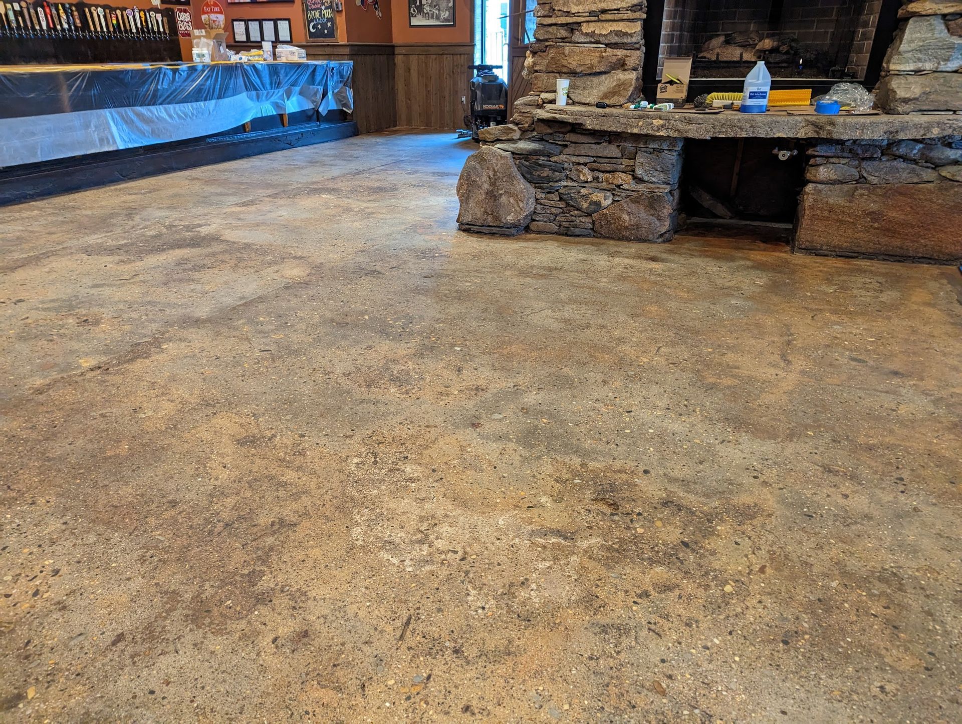 A dirty floor in a room with a fireplace.