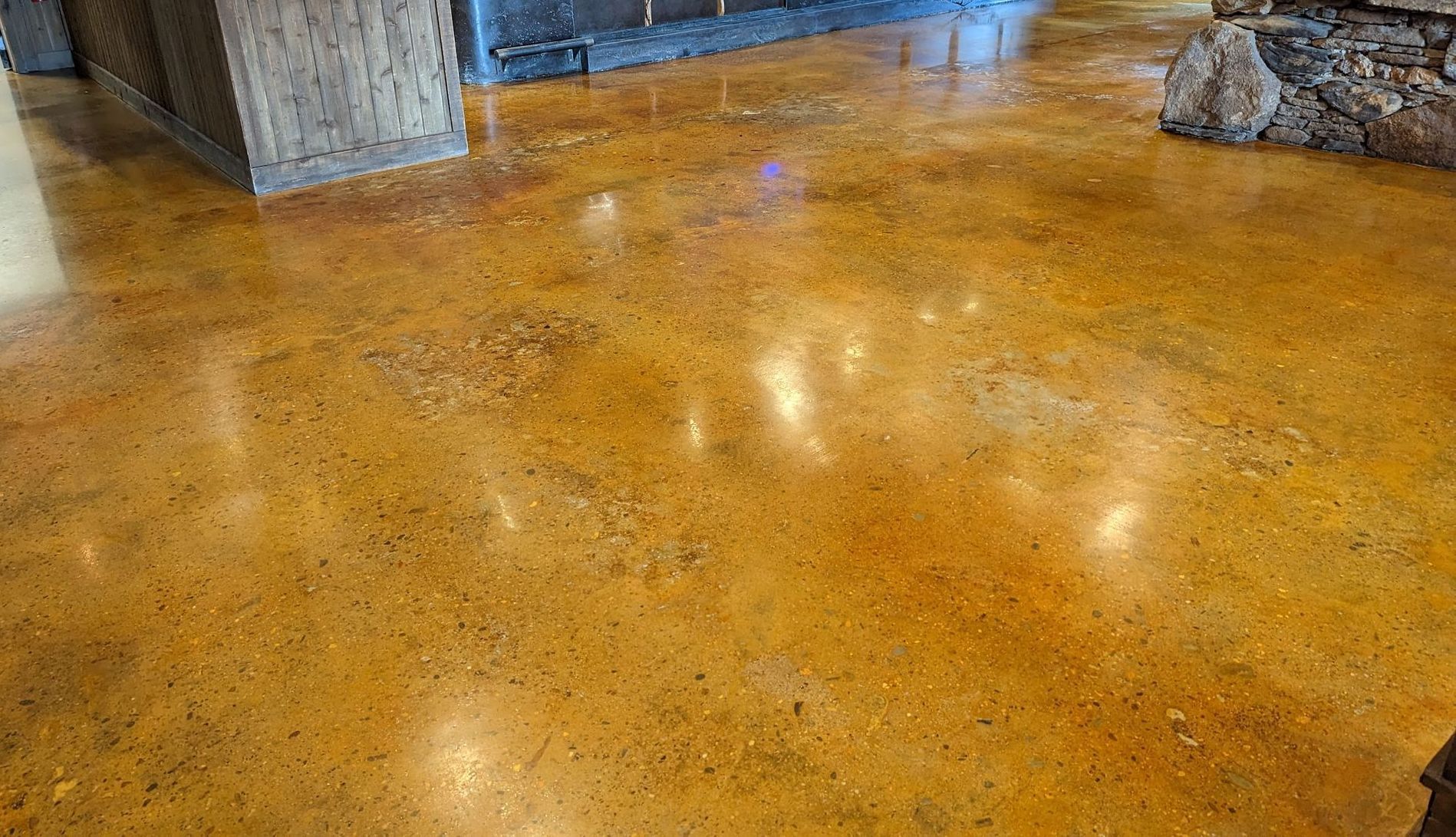 Polished concrete floor with golden-brown tones, reflecting light.