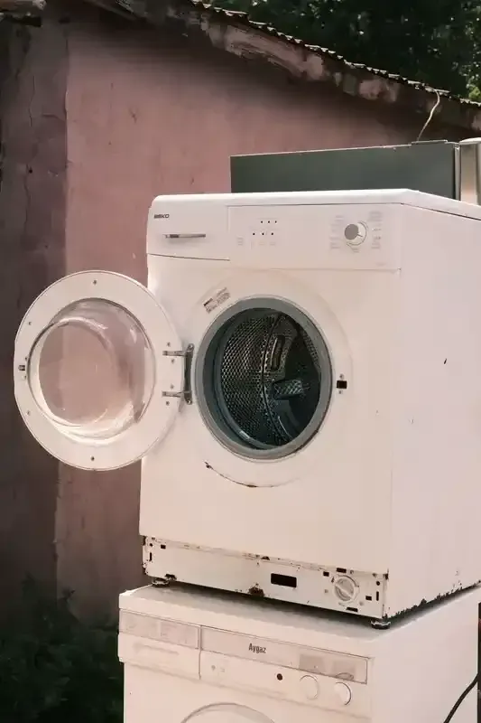 Un mirador con cortinas blancas se encuentra en medio de un exuberante campo verde.