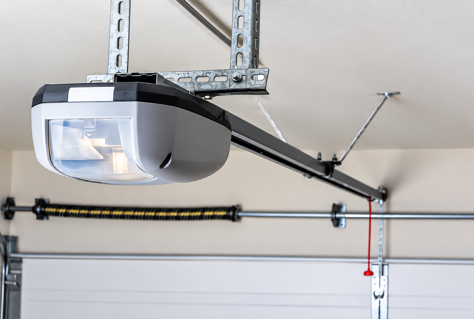 Garage door opener mounted on ceiling above a white garage door