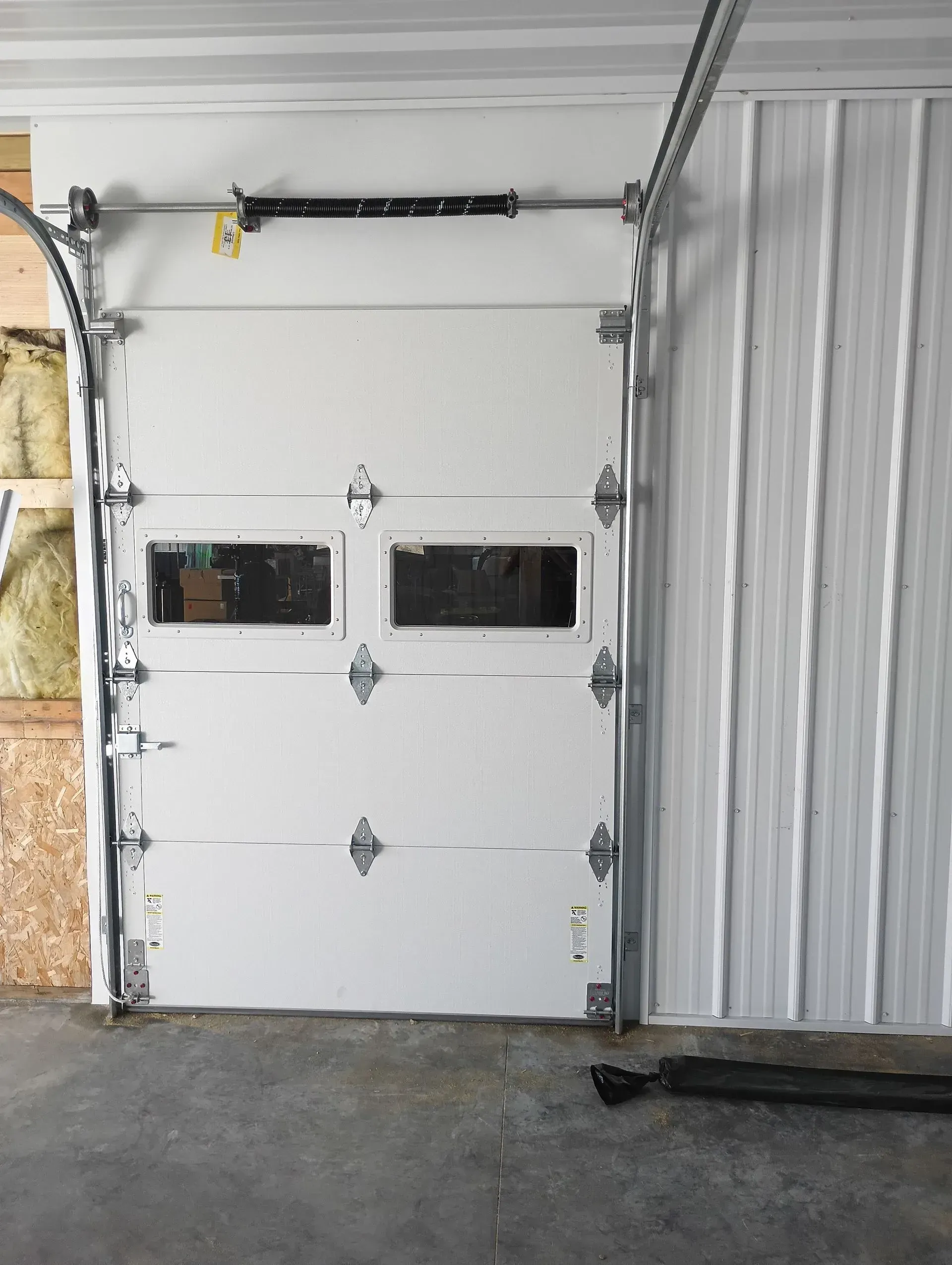 White garage door with two small windows in an indoor garage.
