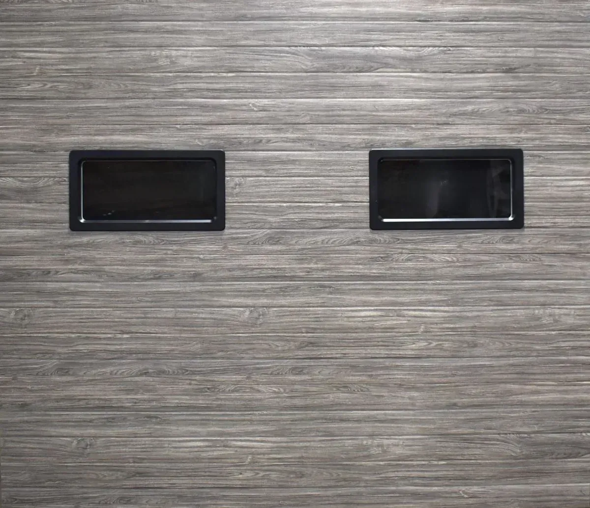 Two black rectangular handles on a gray wood-grain cabinet surface