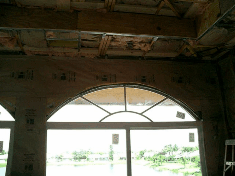 A building under construction with a large arched window
