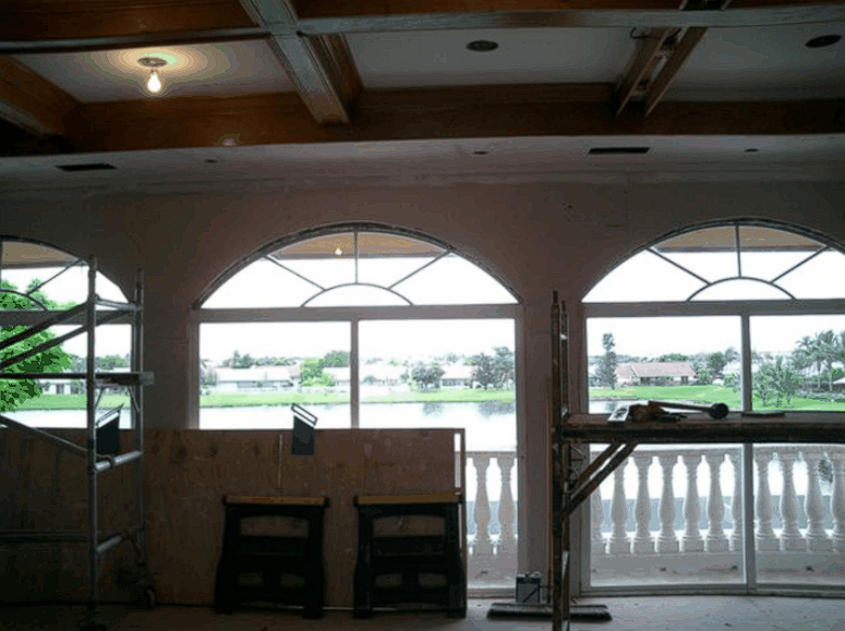 A room with arched windows looking out to a lake