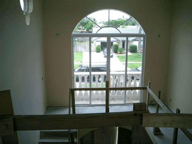 A room with a balcony and a large window