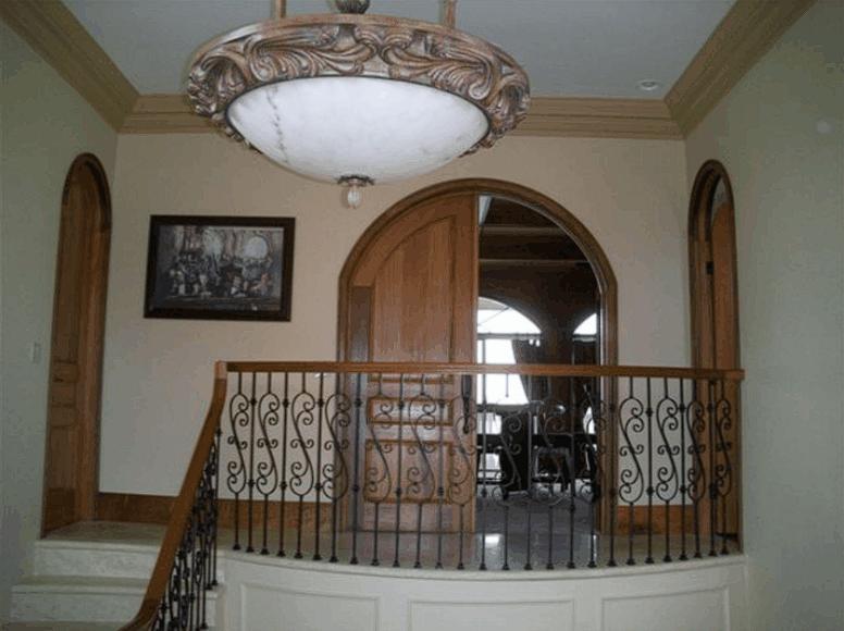 A large chandelier hangs from the ceiling above a staircase