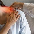 Doctor examining a patient’s neck with a hand, highlighting neck pain in a clinical setting