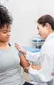 Nurse checking a patient’s arm with a blood pressure cuff in a clinic.