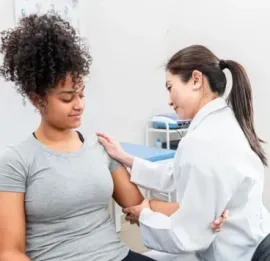 Doctor examining a patient’s arm in a clinic