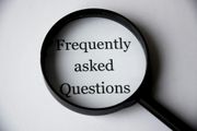 Magnifying glass over the words “Frequently asked Questions” on a gray background