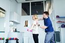 Man helping woman with arm exercise in a bright gym or therapy room