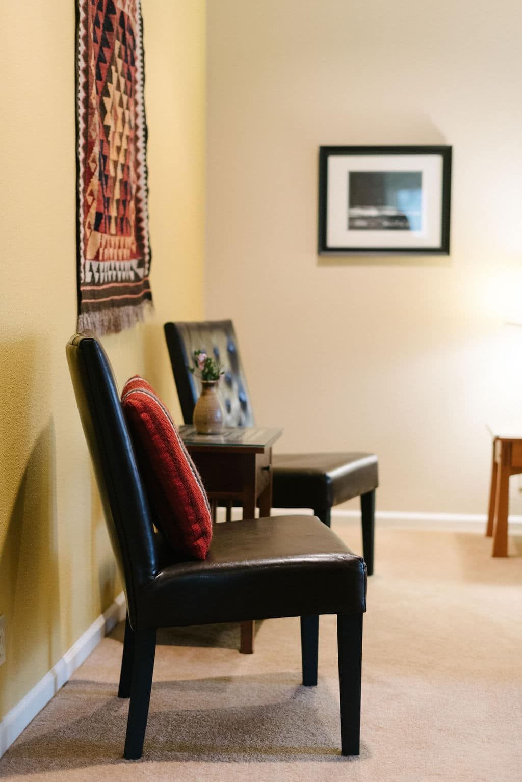 A room with two chairs and a picture on the wall