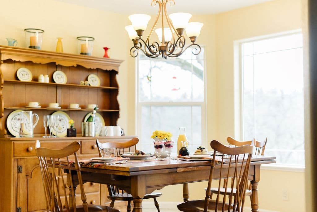 A dining room with a table and chairs and a chandelier
