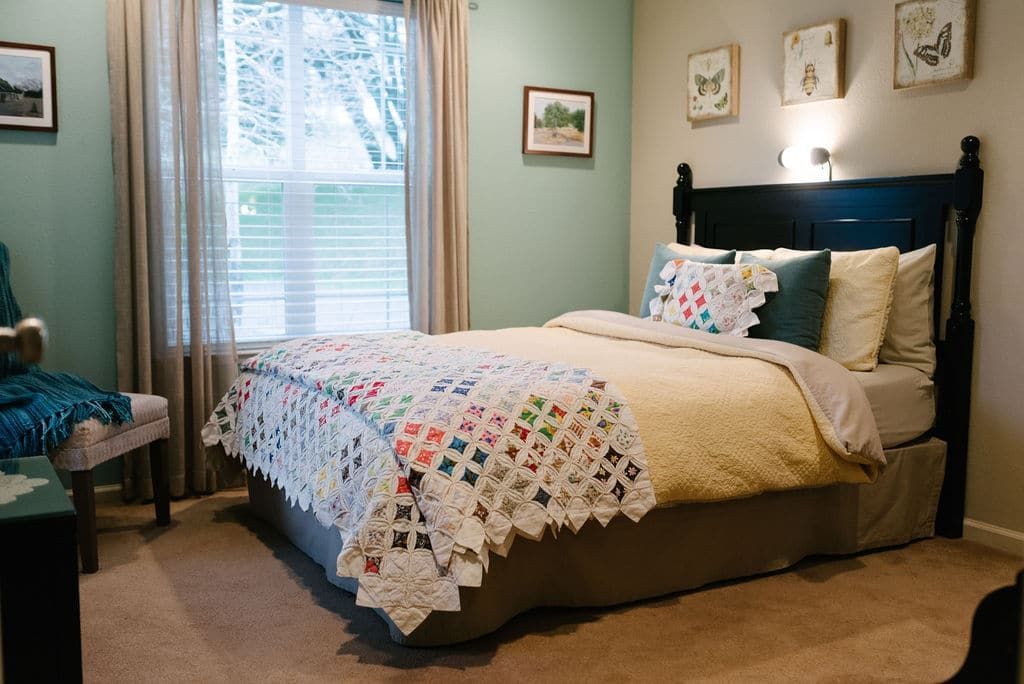 A bedroom with a bed , chair , and window.